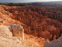 A vibrant red rock landscape of white limestone and forest below