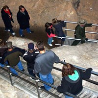 Ranger leading people down stairs during cave tour.