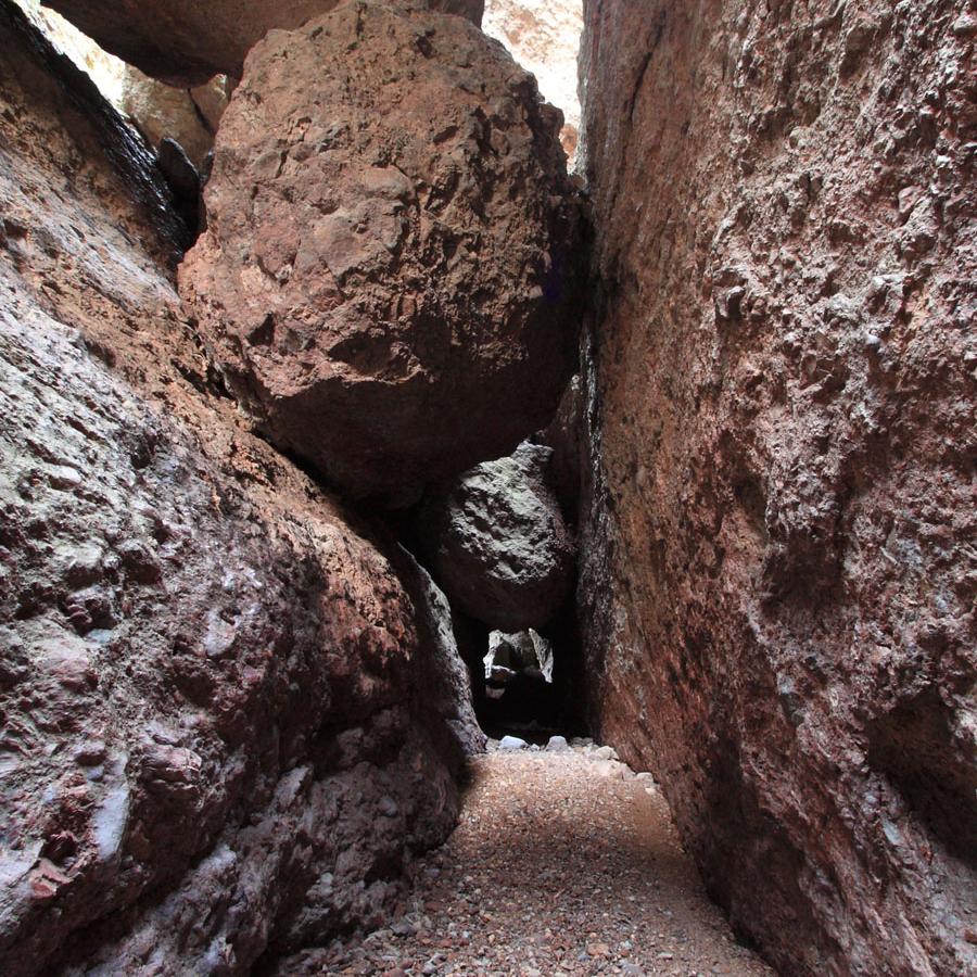 Large boulder wedged in narrow rock canyon.
