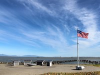 Four memorial stands and a flag can be seen by the waterfront.