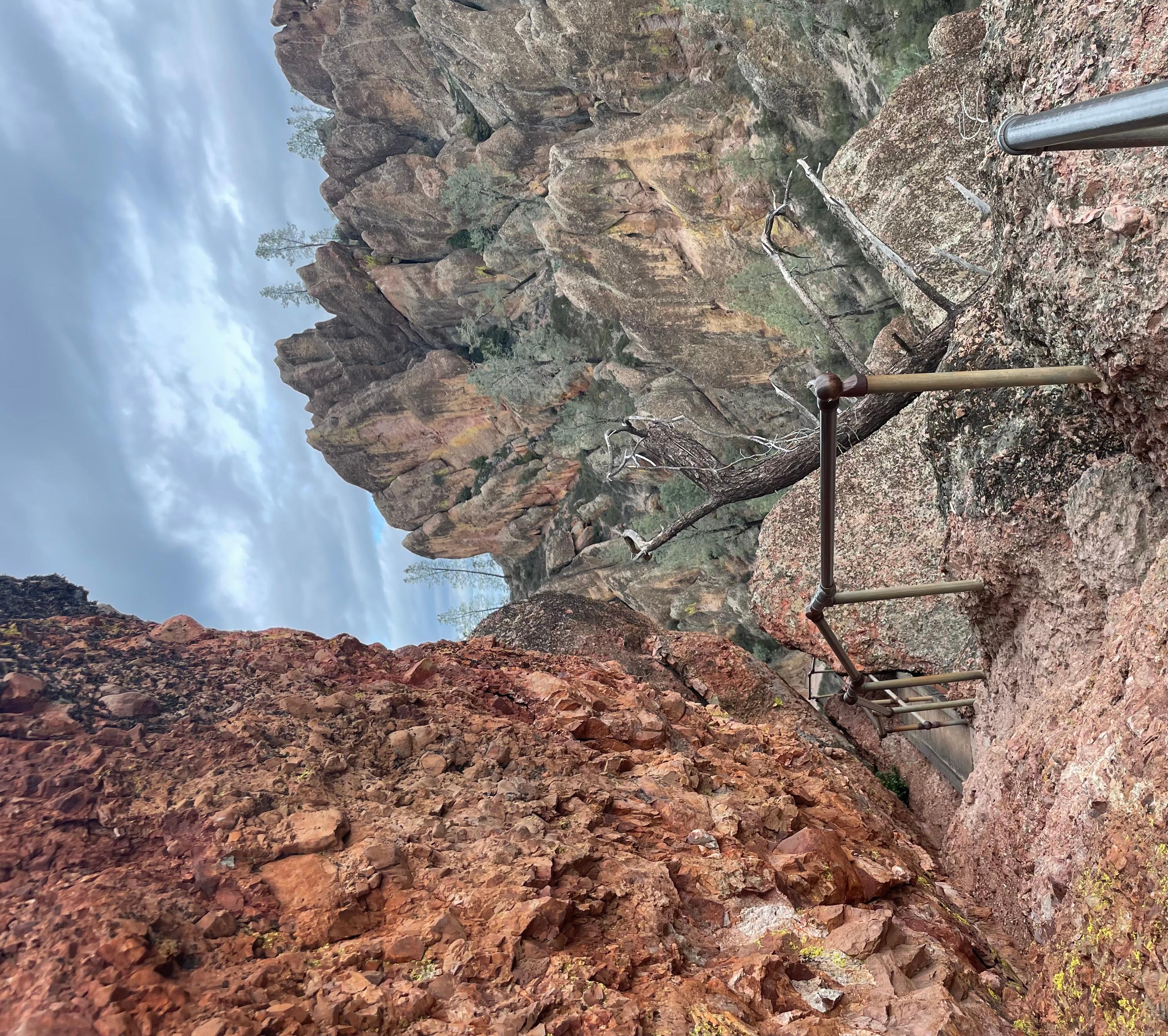 Rocky trail following the edge of a narrow steep rock canyon on stormy afternoon
