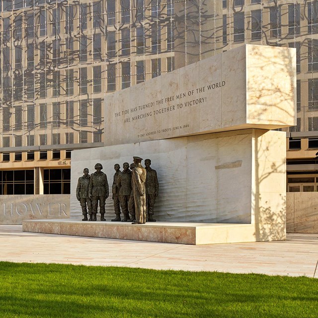 A memorial plaza with benches and trees.