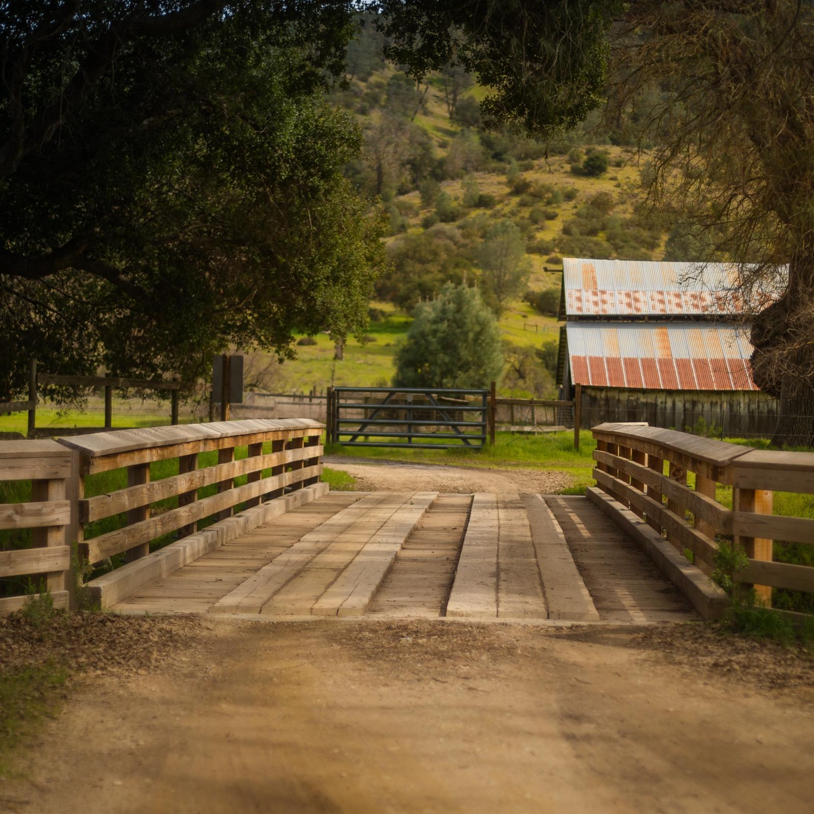 Wooden bridge entry to small ranch.