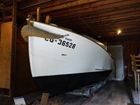 White surfboat on exhibit in the boathouse