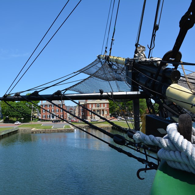 Bow of historic ship with buildings in background