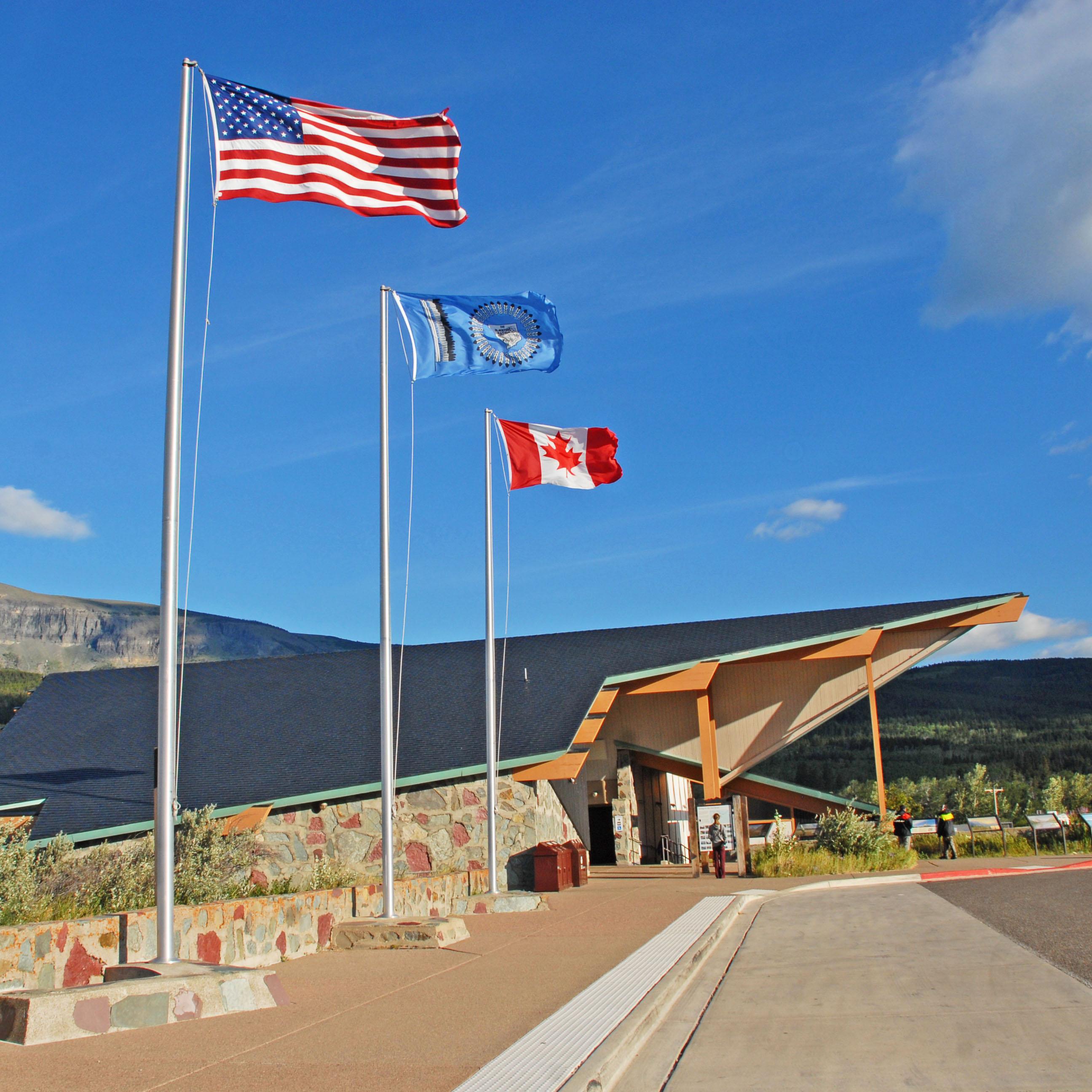Flagpoles in front of modern building with exaggerated roofline