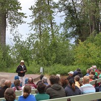 Tribal member addresses crowd seating on benches