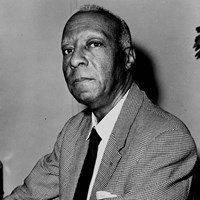 Africacn American man wearing suit jacket and tie and looking into the camera