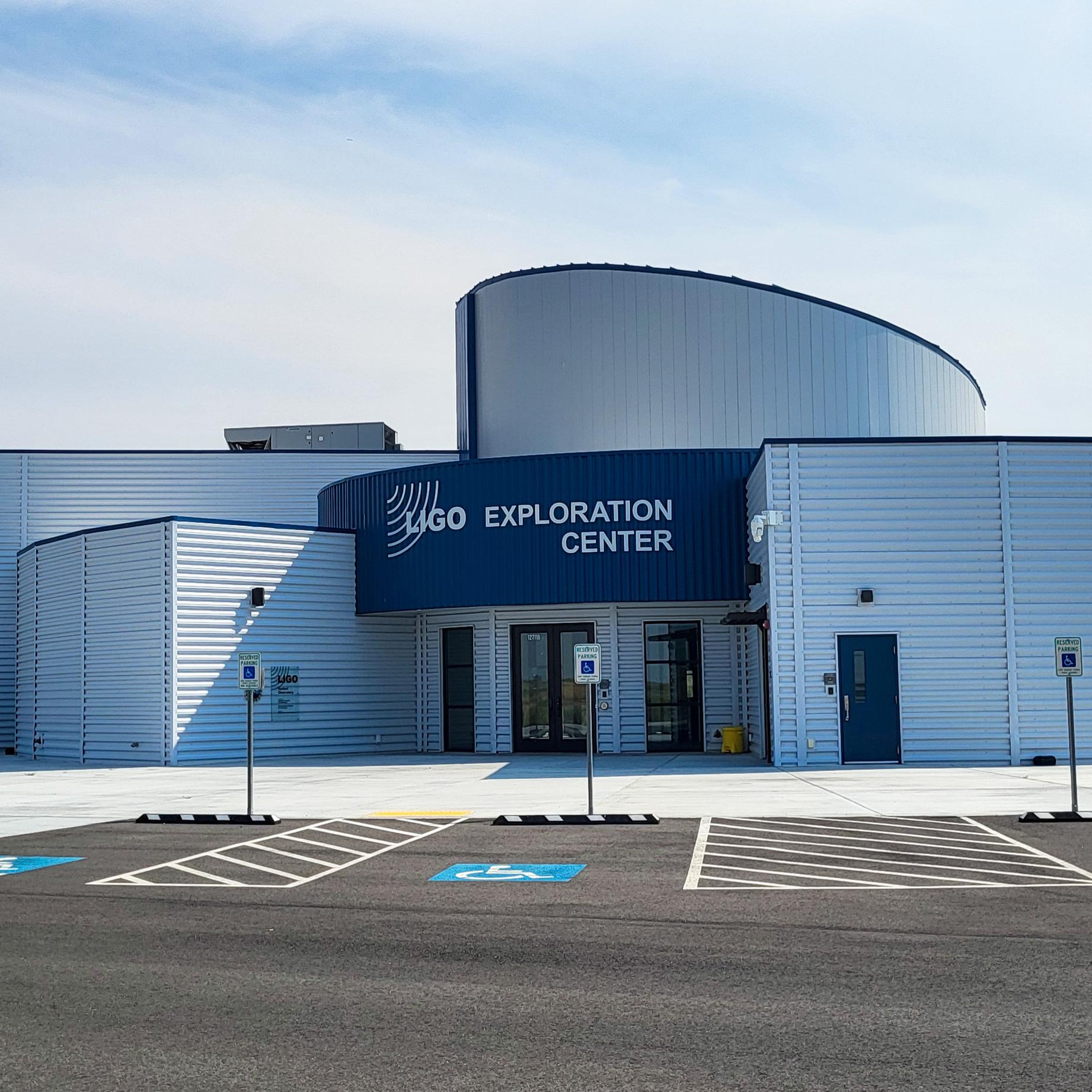 White modern museum with blue entryway and white lettering: “LIGO Exploration Center.”