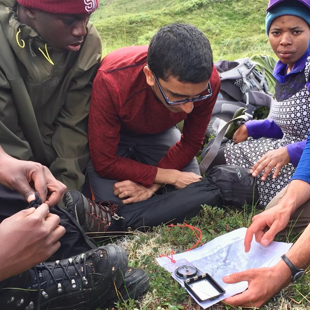 Group of people looking at a map and compass