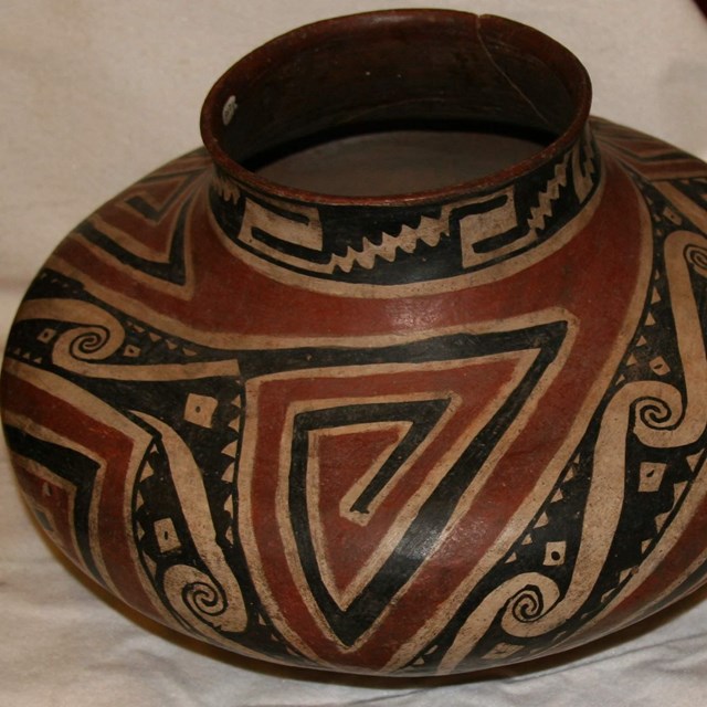 Close-up detail of black, red, and tan pot