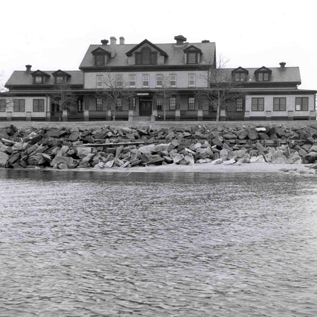 Black and white image of historic hospital at ocean\'s edge