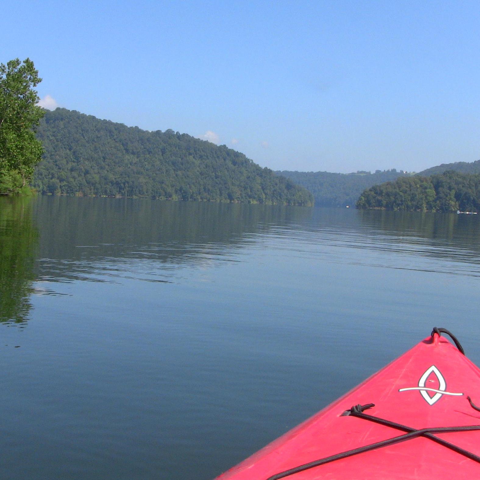 view of lake with trees on all sides from cockpit of a kayak 