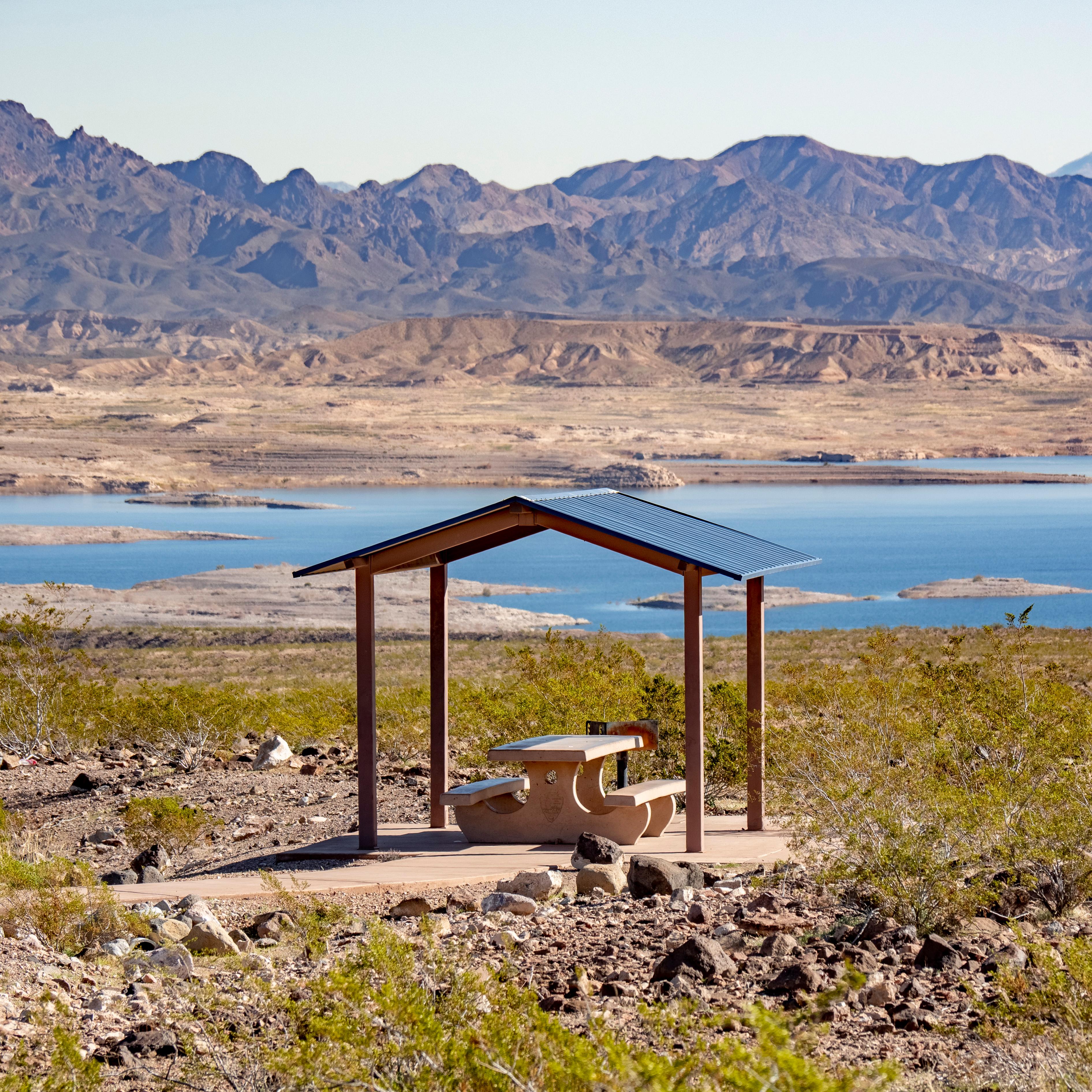 a picnic shelter with a lake in the background