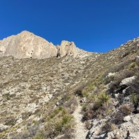 A stone trail winds up a steep desert slope.