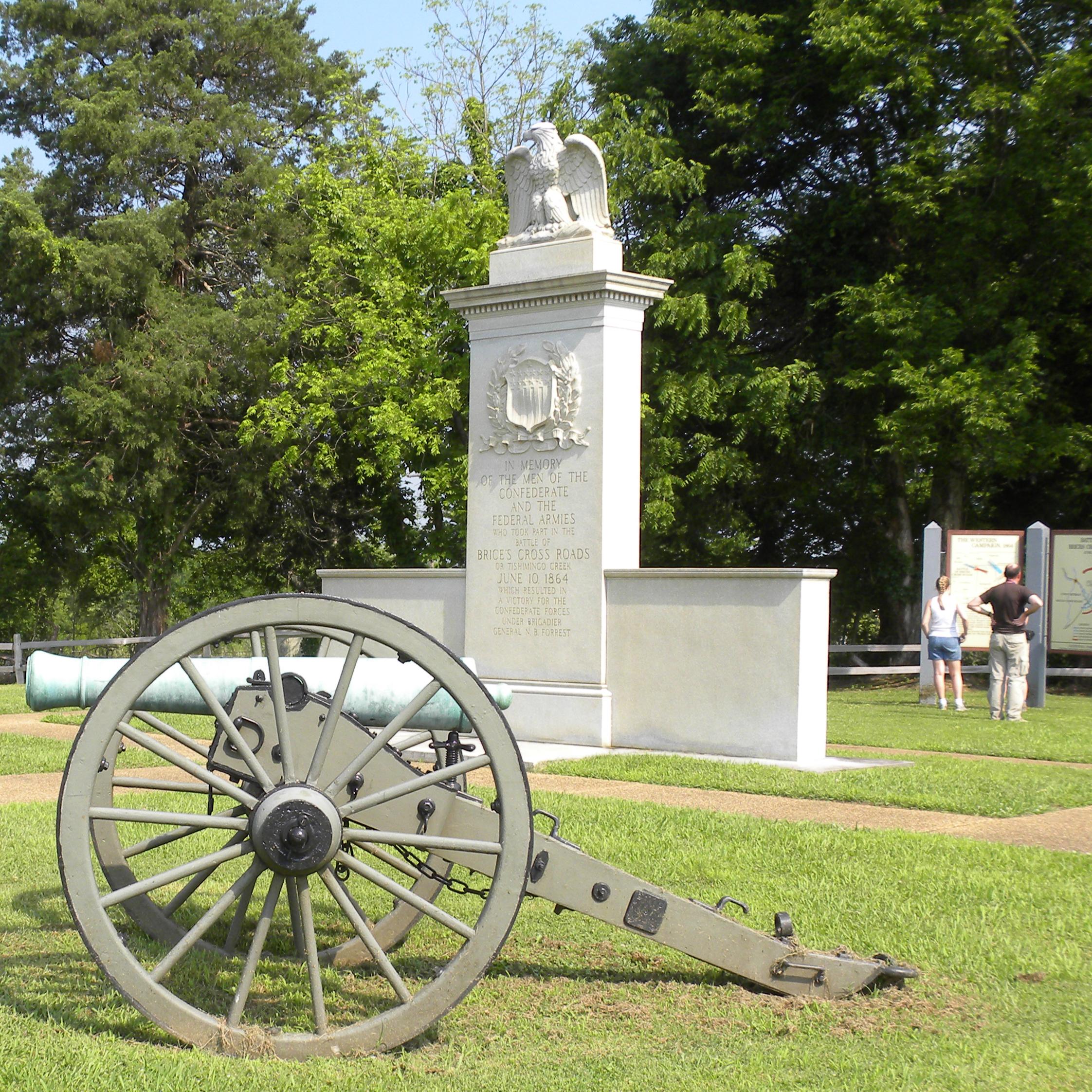 Brices Cross Roads National Battlefield Monument in middle with cannon in front.
