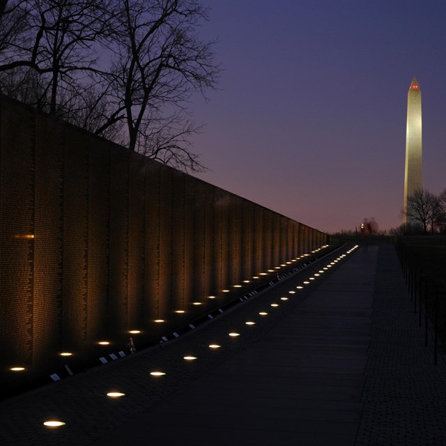 Vietnam Veterans Memorial at night, with lights leading toward Washington Monument