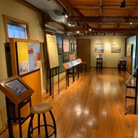 Museum with computer to the left and textual exhibits on all sides.