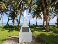 A white obelisk with a round ball with an eagle perched on it on the top.