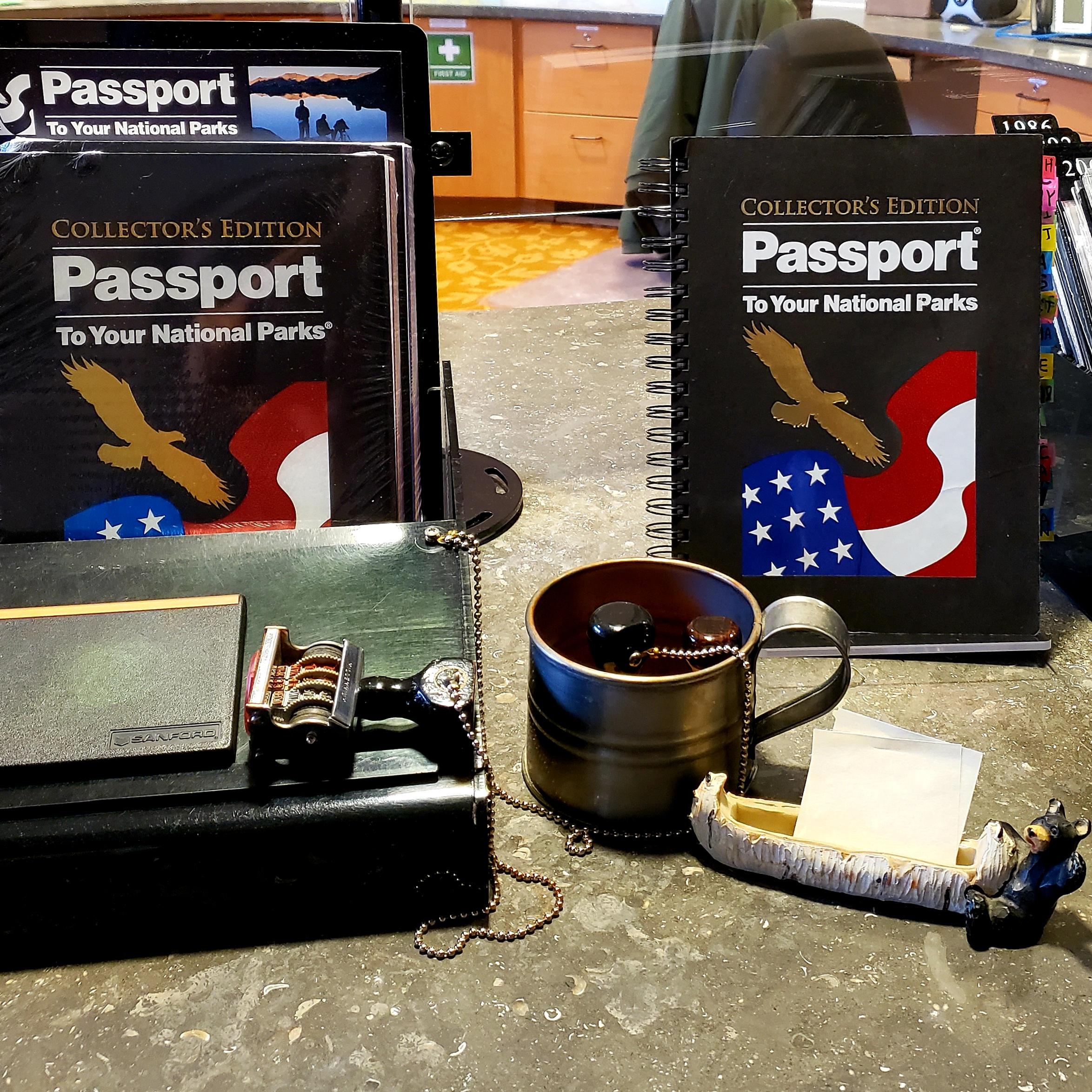 Desktop display with National Parks passport books and date stamp.