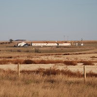 View of a ranch-style building inside a fenced compound