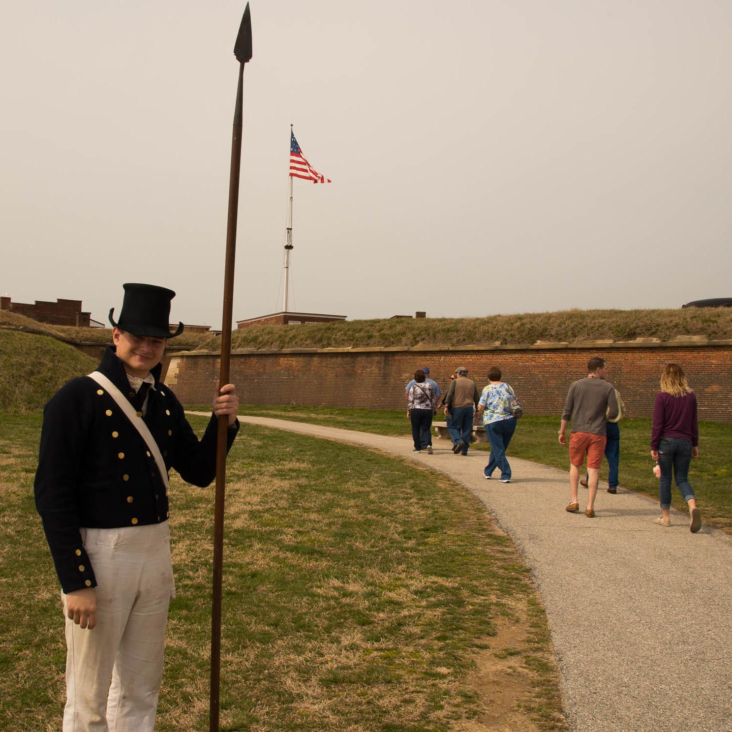 A living historian greets visitors at the entrance of the historic zone.