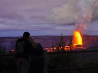 A couple views an eruption at night.