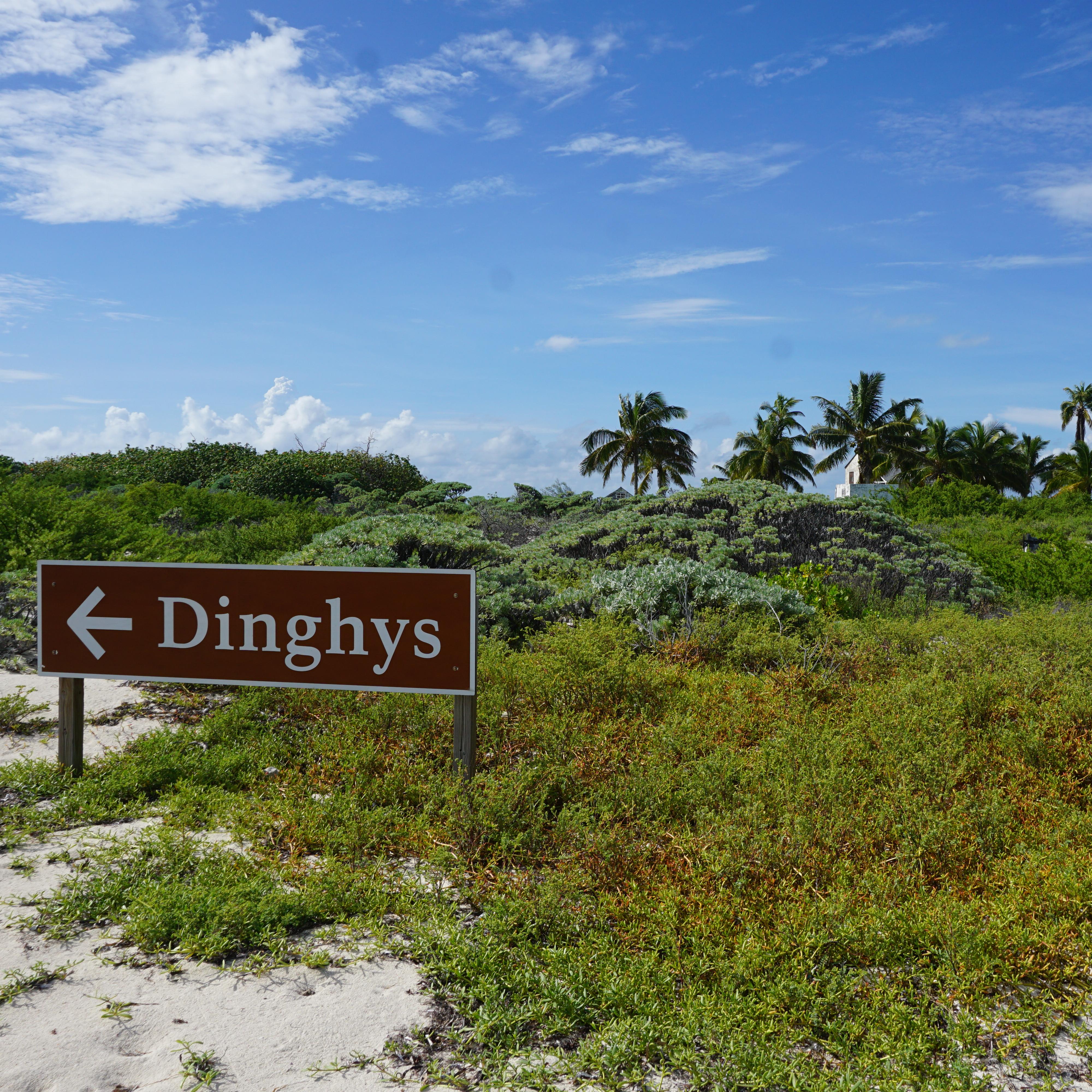 A metal park service sign planted in the sand that reads 