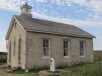 Lower Fox Creek School built of limestone with a wooden shake shingle roof and bellfry