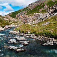 a shallow river flowing between mountains