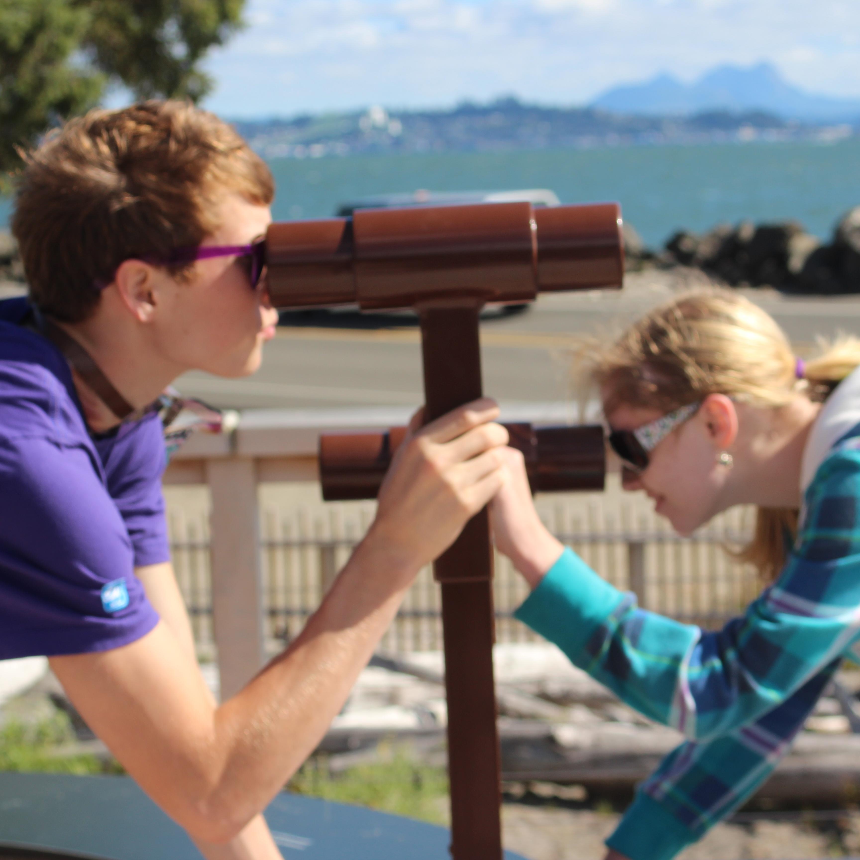 Film camp youth learning about surveying at Middle Village