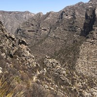 A trail runs through a small gap in a ridge