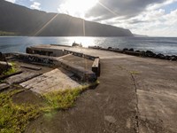 A short cement dock, ocean, and sea cliffs