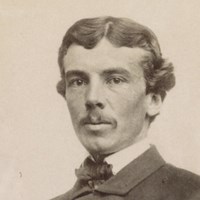A young Civil War cavalry officer poses seated in uniform.