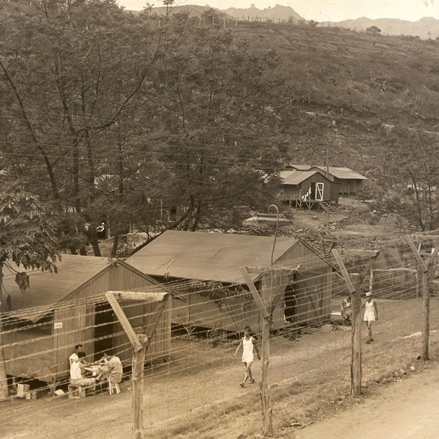 B&W photo of barbed wire camp in the barren mountains
