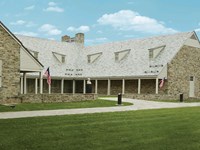 A one-story fieldstone building surrounding a central courtyard.