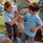 A kid and an archaeologist give each other a high five.