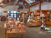 A large indoor space is full of tables and displays featuring books, souvenirs, and gifts.