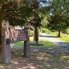 Sign with formline art posts and a beach at low tide
