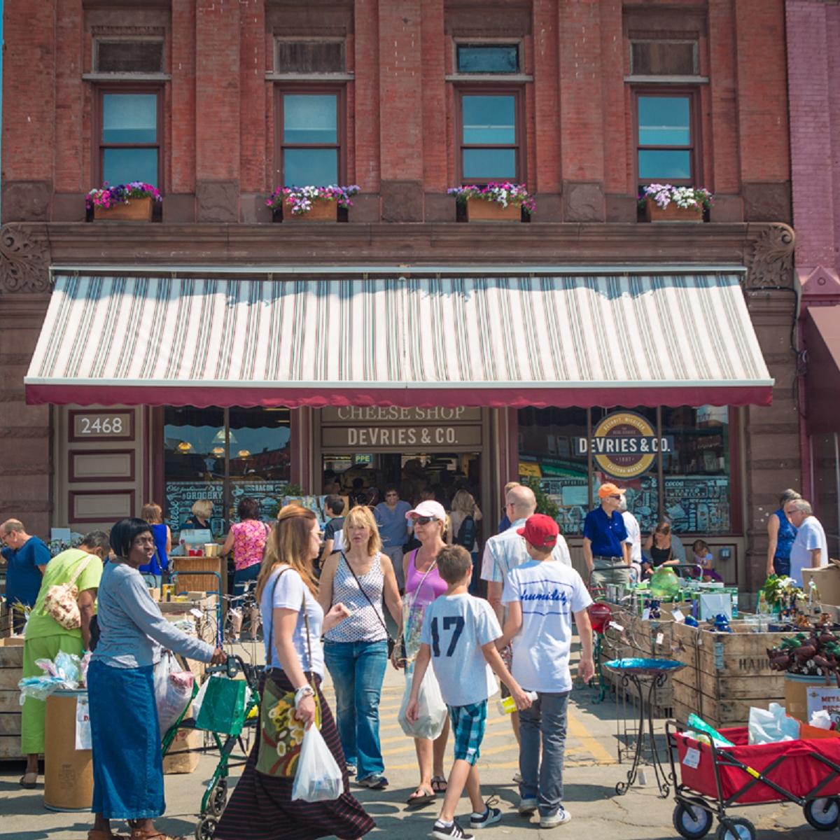 Photo of people outside row of restaurants. 