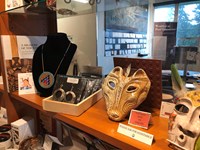 Clay masks and jewelry sit on a shelf.