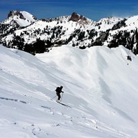 a lone skier on a steep mountain slope
