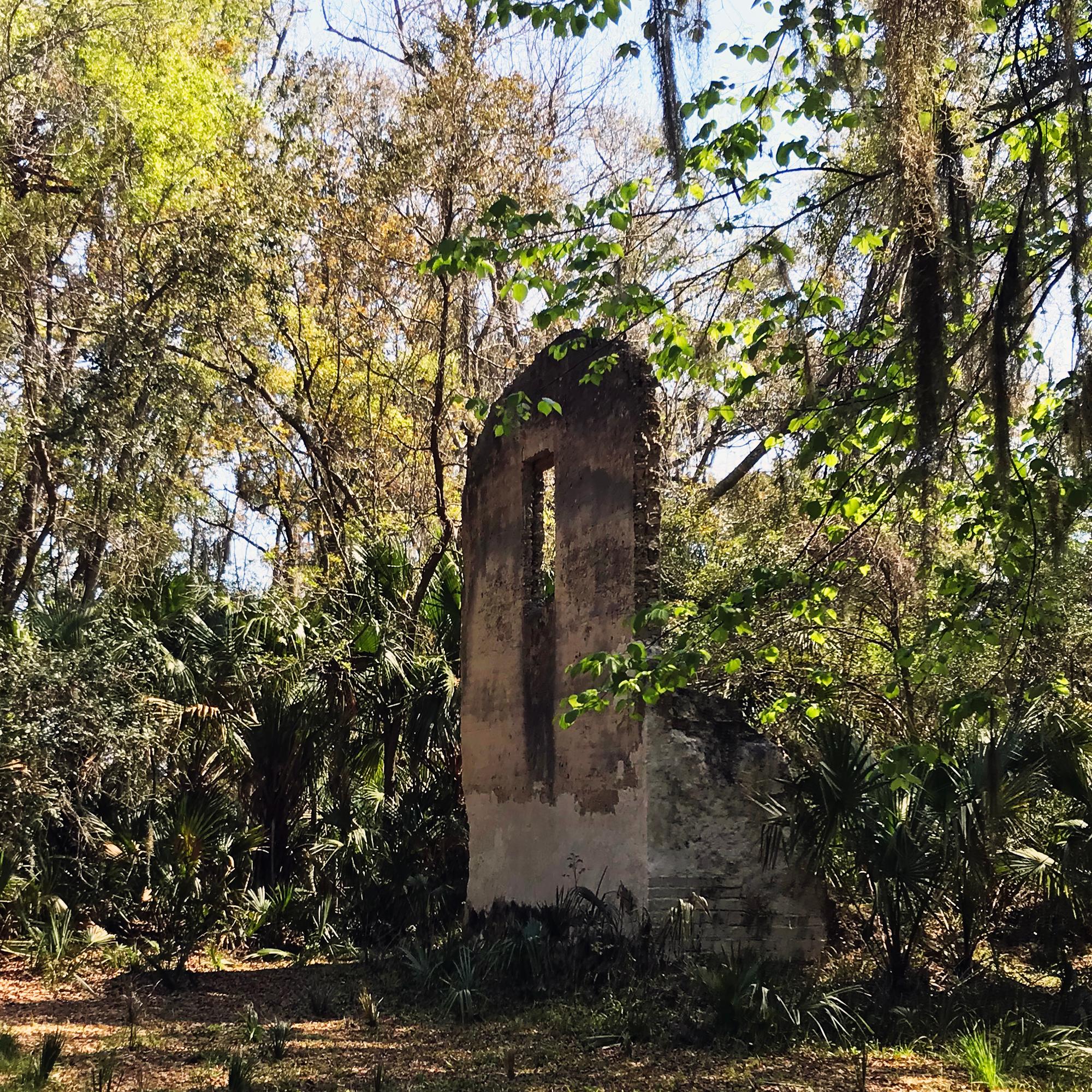 two story tabby wall with window in the woods