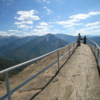 People stand along the narrow ridge of Moro Rock, surrounded by railing. Photo Paul Johnson