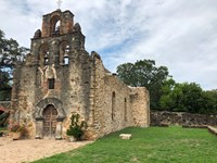 Mission Espada stone church with bell tower.