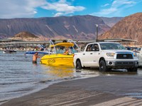 Launch ramp into the lake with several trucks and boats.
