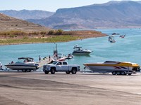 Launch ramp into the lake with several trucks and boats.