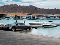 Launch ramp into the lake with several trucks and boats.