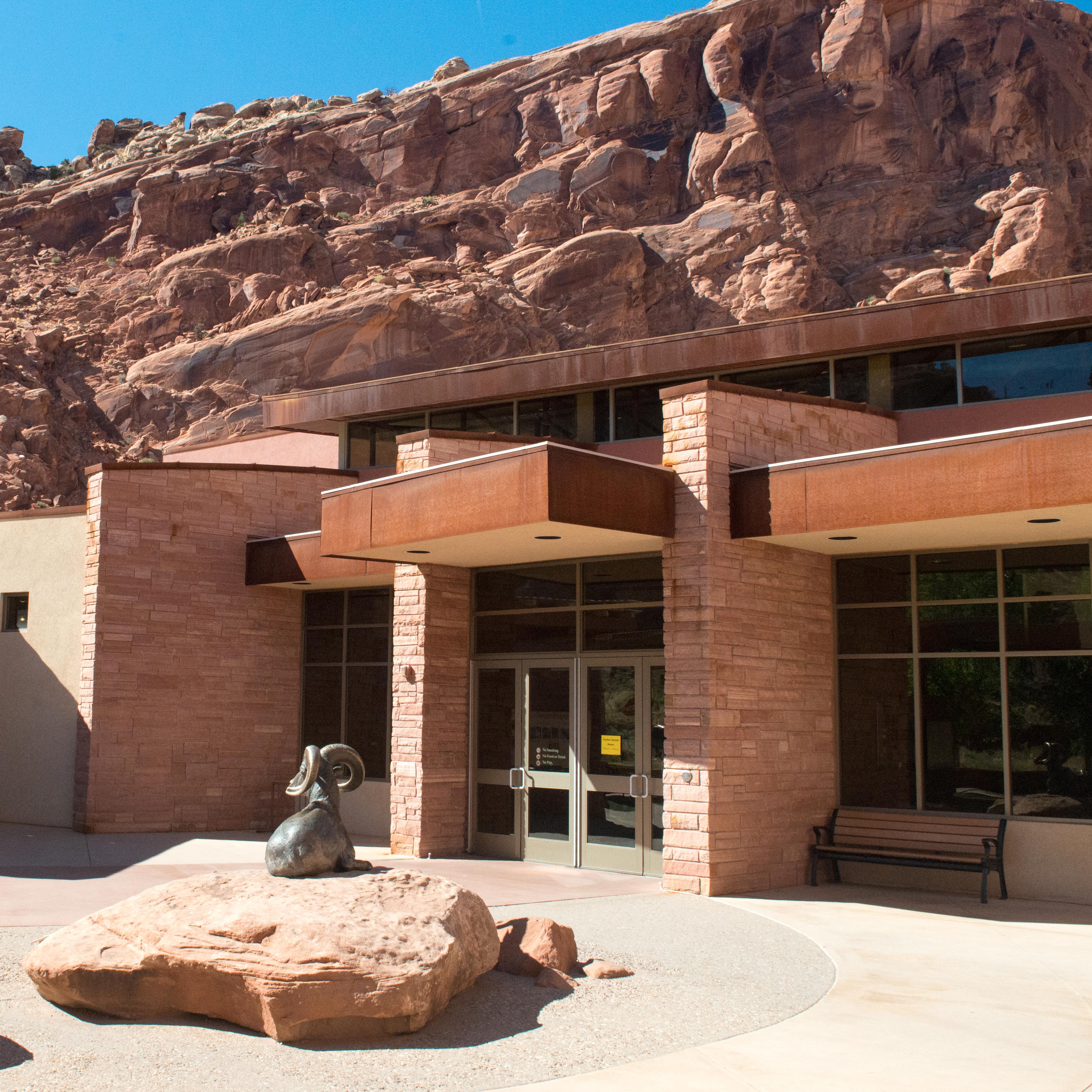 a red stone building with sculptures of animals in front