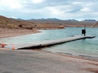 Launch ramp into the lake with several trucks and boats.
